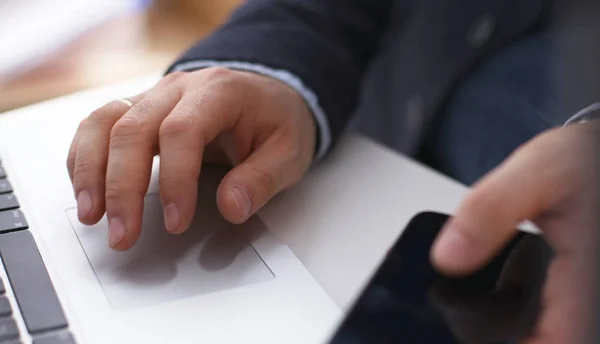 Primer plano de la mano del hombre de negocios que trabaja en la computadora portátil de pantalla en blanco en el escritorio de madera como concepto — Foto de Stock