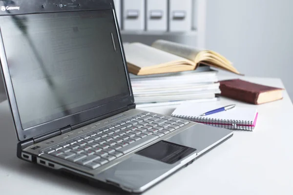 Bureau met lege laptop, computertoetsenbord en andere kantoorbenodigdheden — Stockfoto