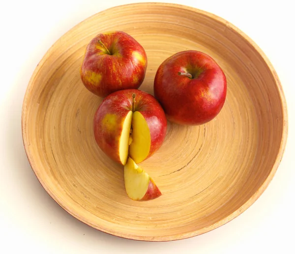 Wooden plate with ripe fresh red apples — Stock Photo, Image