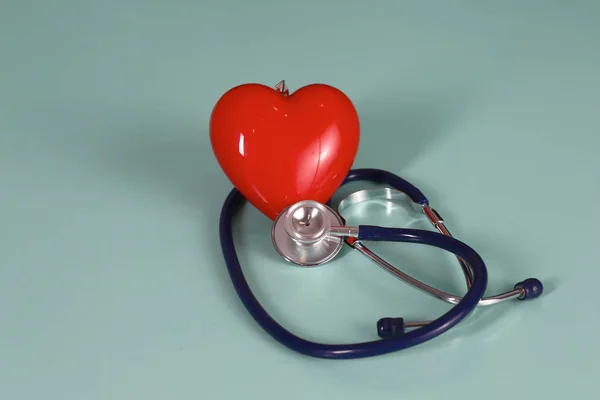 Inima roșie și un stetoscop pe birou — Fotografie, imagine de stoc
