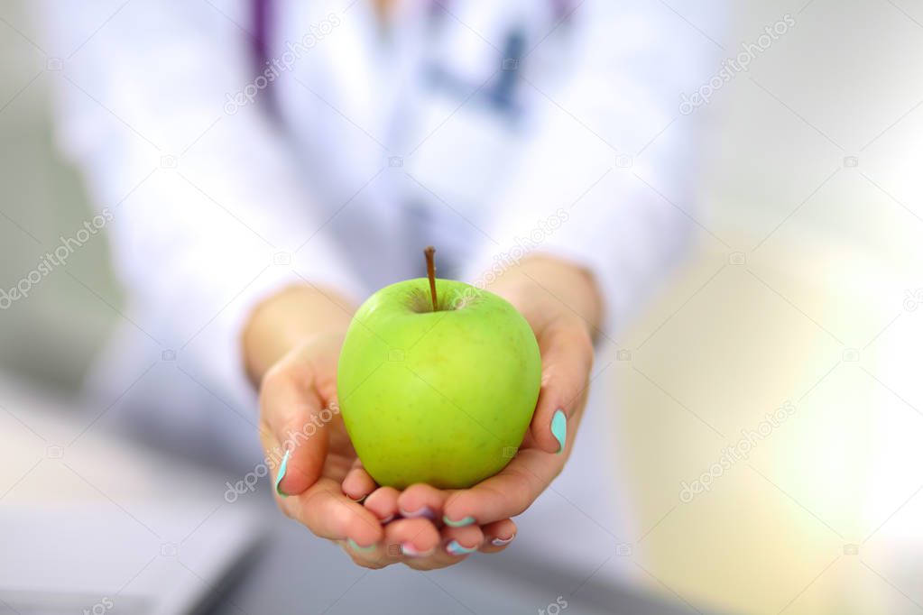 Doctor holding fresh green apples, closeup shot