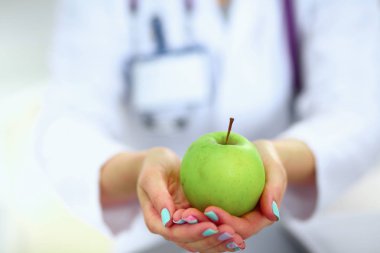 Doktor, taze yeşil elma tutan portre vurdu