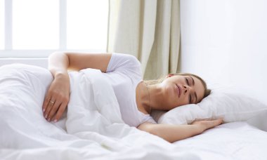 Güzel kız yatakta yatarken yatak odasında, uyuyor