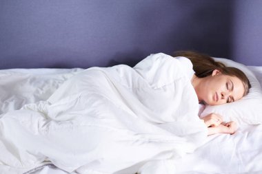 Güzel kız yatakta yatarken yatak odasında, uyuyor