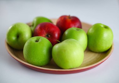 Yeşil ve Kırmızı elma beyaz masaya yatıyor