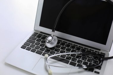 Bir dizüstü bilgisayar klavye online m kavramı içinde yatan stetoskop