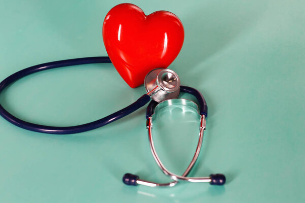 Red heart with stethoscope on blue wooden background. Copy space. Valentines day.