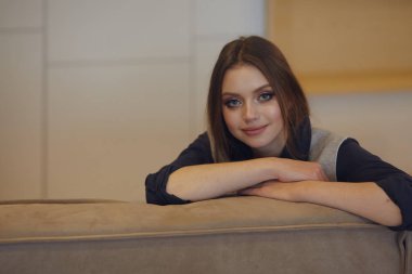 güzel bir genç kadın evde koltukta dinleniyor