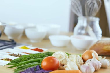 Ahşap tahtalı kompozisyon ve masada yemek pişirmek için malzemeler