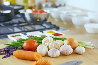 Ahşap tahtalı kompozisyon ve masada yemek pişirmek için malzemeler