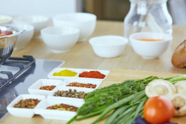 Ahşap tahtalı kompozisyon ve masada yemek pişirmek için malzemeler