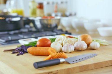 Ahşap tahtalı kompozisyon ve masada yemek pişirmek için malzemeler