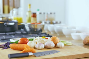 Ahşap tahtalı kompozisyon ve masada yemek pişirmek için malzemeler