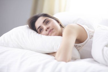 güzel genç kadın yatakta sabah tadını çıkarma. Güzel Model yüz kamera seksi görünüyor