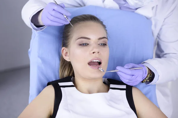 Hermosa chica en la silla dental en el examen en el dentista —  Fotos de Stock