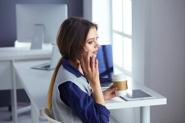 Εστιασμένη προσεκτικός γυναίκα ακουστικά κάθεται στο γραφείο με το laptop, φαίνεται στην οθόνη, κάνει σημειώσεις, μαθαίνει την ξένη γλώσσα στο διαδίκτυο — Φωτογραφία Αρχείου