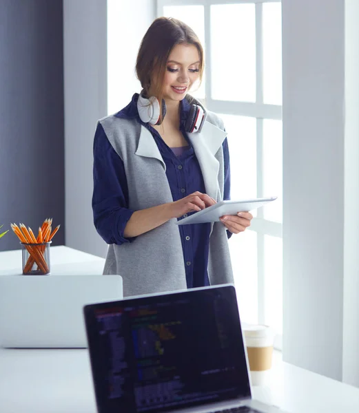 Konzentrierte, aufmerksame Frau mit Kopfhörern sitzt am Schreibtisch mit Laptop, blickt auf den Bildschirm, macht Notizen, lernt Fremdsprache im Internet — Stockfoto