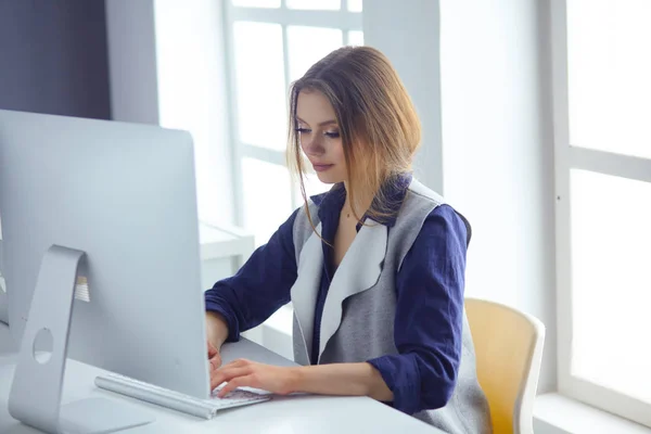 Сосредоточенная внимательная женщина в наушниках сидит за столом с ноутбуком, смотрит на экран, делает заметки, учит иностранный язык в интернете — стоковое фото