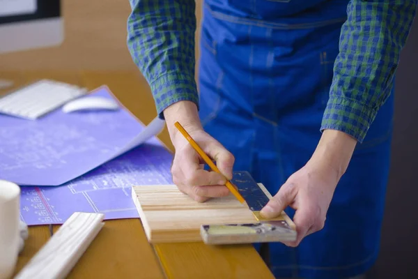 Beroep, timmerwerk, houtbewerking en mensen concept - timmerman testen houten plank gelijkmatigheid op workshop — Stockfoto