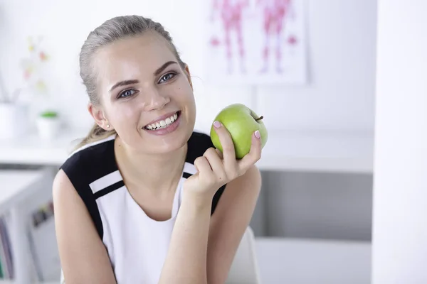 Unga vackra leende flicka med ett grönt äpple i händer — Stockfoto