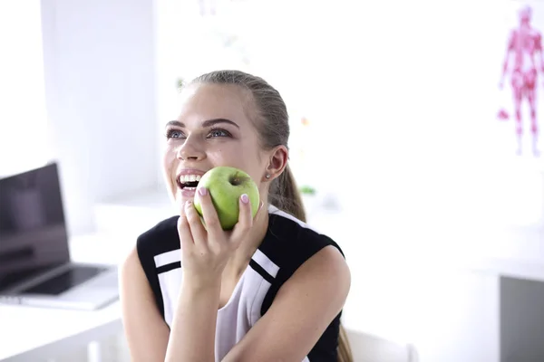 Unga vackra leende flicka med ett grönt äpple i händer — Stockfoto