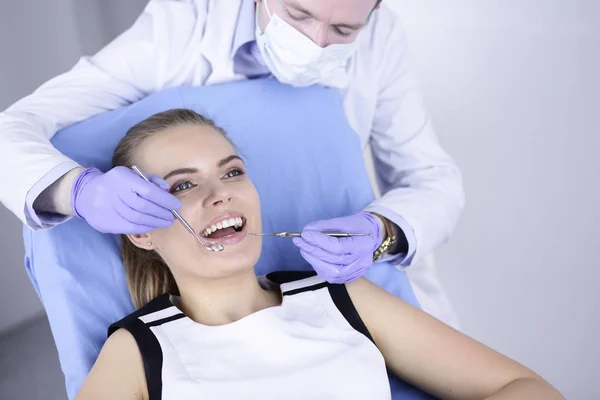 Hermosa chica en la silla dental en el examen en el dentista —  Fotos de Stock