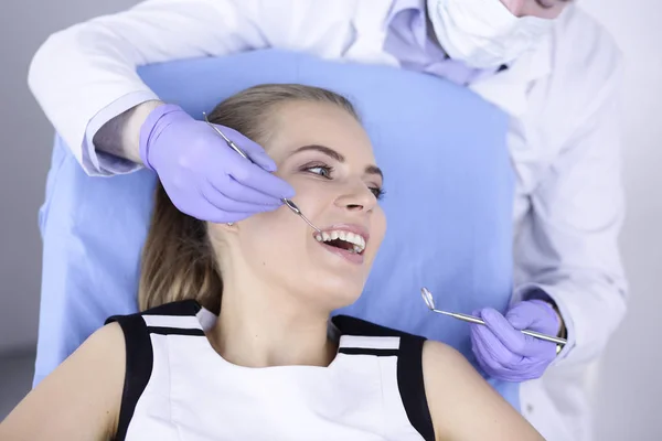 Красивая девушка в стоматологическом кресле на осмотре у стоматолога — стоковое фото