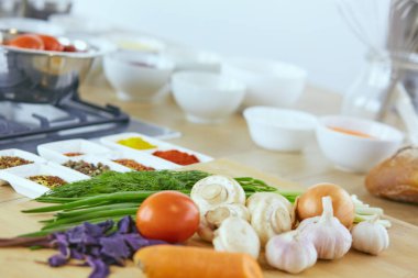 Ahşap tahtalı kompozisyon ve masada yemek pişirmek için malzemeler