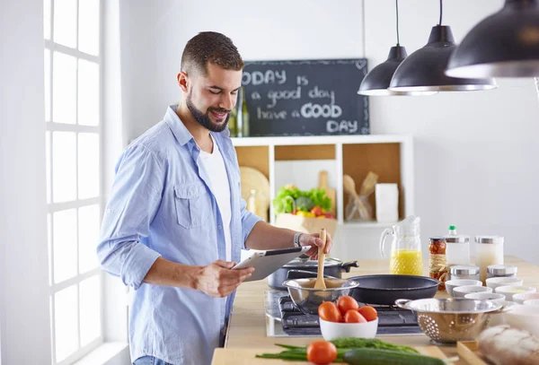 Улыбающийся и уверенный шеф-повар стоит на большой кухне — стоковое фото