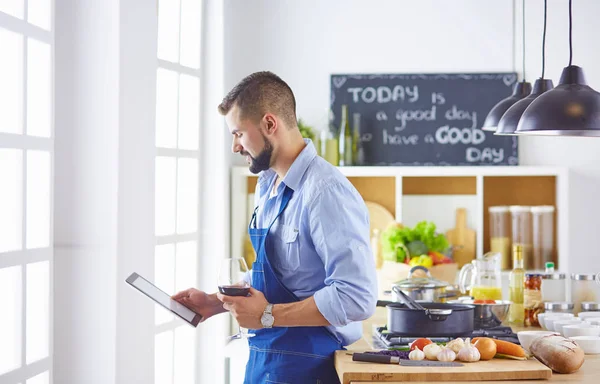 cook with a tablet in hand and studying the recipe