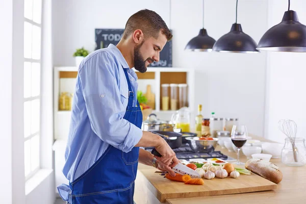 Jovem chef prepara um homem na cozinha — Fotografia de Stock