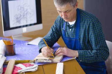 Dizüstü bilgisayarda çalışan ve Proje çizimi mühendis marangoz