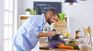 Büyük mutfak tatma içinde ayakta gülümseyen ve kendine güvenen Şef 