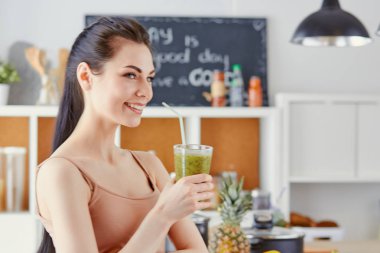 genç bir kız bir kokteyl bir mutfak içecekler.