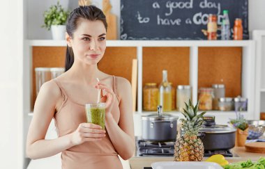 genç bir kız bir kokteyl bir mutfak içecekler.