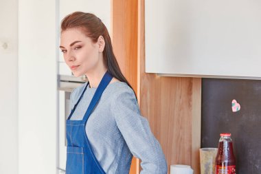 Genç güzel ev kadını mutfakta pişirme sonra dinlenme