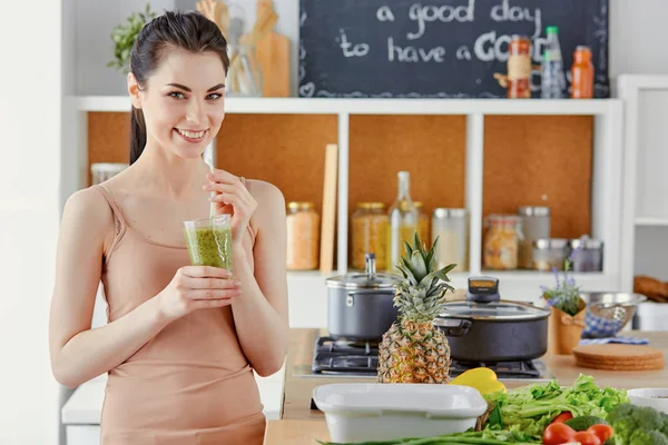 A young girl drinks a cocktail on a kitchen — Stock Photo, Image