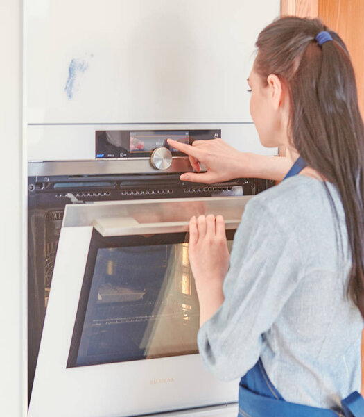 Beautiful woman in the kitchen, waiting with the front of the o