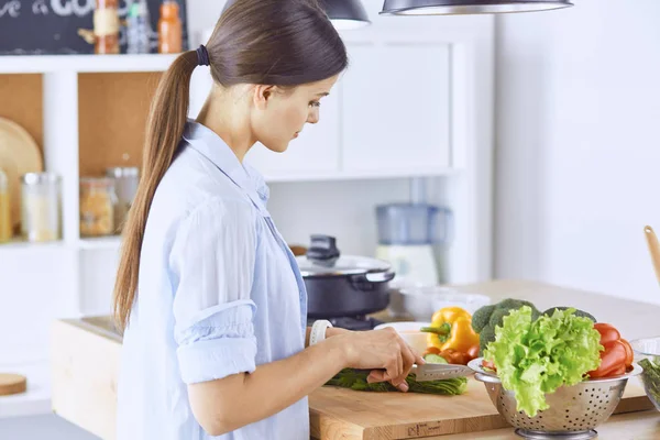 Młoda kobieta przygotowuje jedzenie w kuchni. Zdrowa żywność - vege — Zdjęcie stockowe