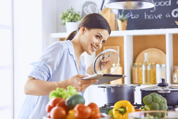 Imagen de una joven chica bonita de pie en la cocina y es coo — Foto de Stock