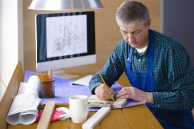 Dizüstü bilgisayarda çalışan ve Proje çizimi mühendis marangoz