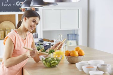 Mutlu genç aşçı kız Yeşiller gıda hazırlama