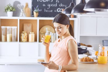 Cep telefonu görünümlü ve cam tutan gülümseyen güzel kadın 