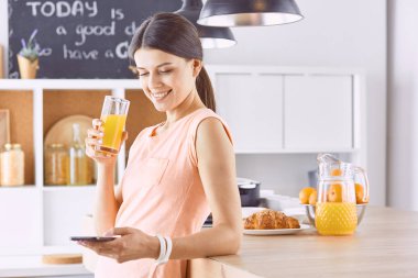 Cep telefonu görünümlü ve cam tutan gülümseyen güzel kadın 