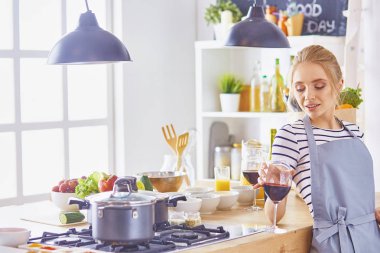 Mutfakta dijital tablet kullanan güzel genç bir kadın.