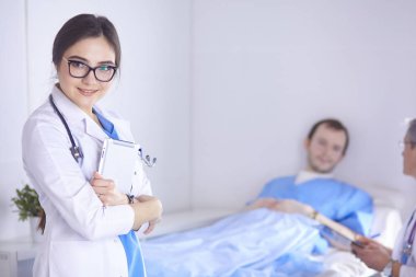 Doktor stetoskop ile yatakta hasta kalp ritmini kontrol