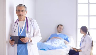 Doktor stetoskop ile yatakta hasta kalp ritmini kontrol