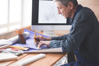 Dizüstü bilgisayarda çalışan ve Proje çizimi mühendis marangoz