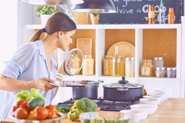 Młoda kobieta przygotowuje jedzenie w kuchni. Zdrowa żywność - vege — Zdjęcie stockowe