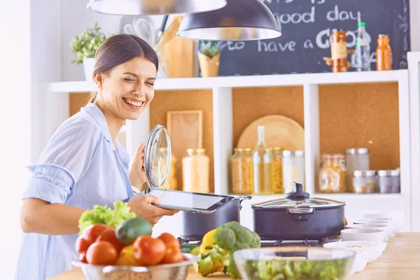 Młoda kobieta przygotowuje jedzenie w kuchni. Zdrowa żywność - vege — Zdjęcie stockowe